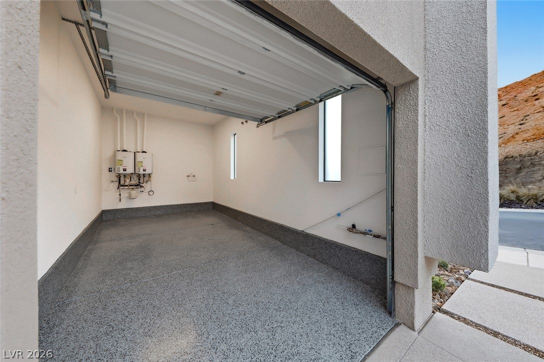 30 Sand Star Lane, Henderson, NV 89011 Polished epoxy flooring and a high-clearance garage door highlight this clean utility space.