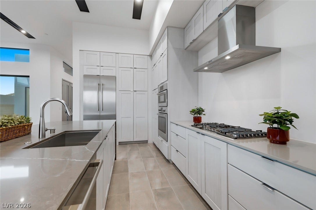 30 Sand Star Lane, Henderson, NV 89011 Polished stone countertops complement sleek white cabinetry in this contemporary kitchen workspace.