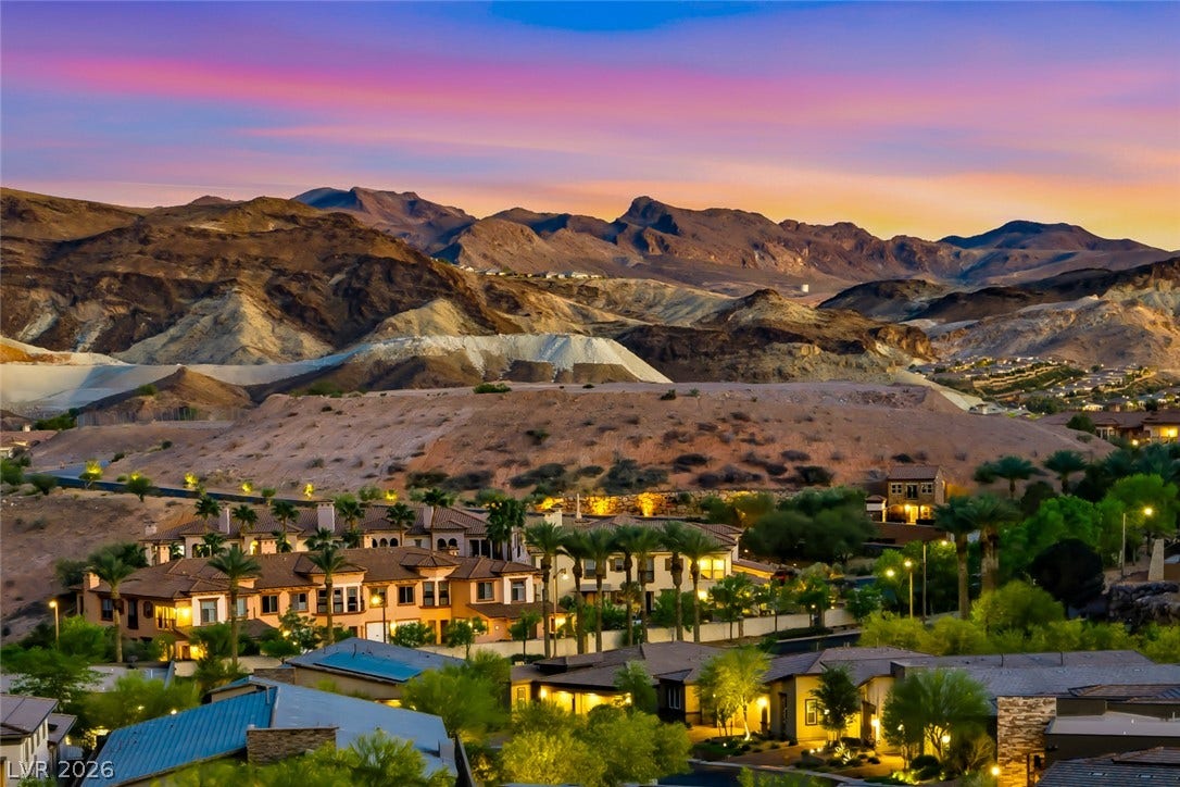 30 Sand Star Lane, Henderson, NV 89011 Dramatic mountain vistas rise above the peaceful desert neighborhood under a vibrant twilight sky.
