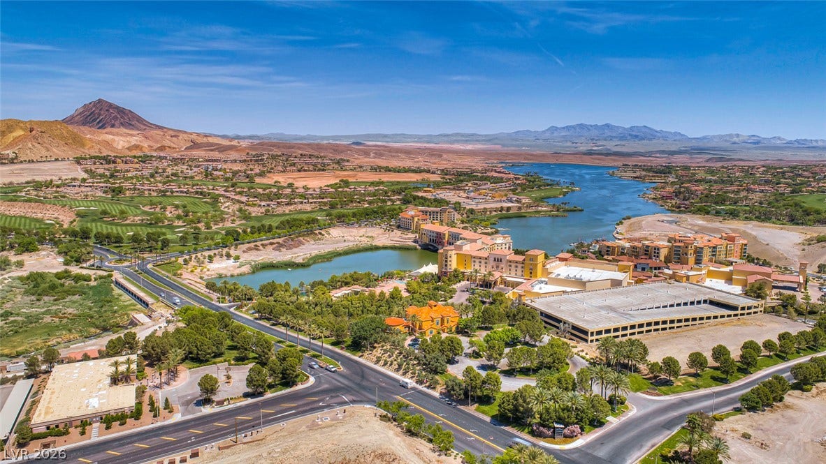 30 Sand Star Lane, Henderson, NV 89011 A sweeping panorama captures the surrounding desert landscape, community structures, and serene lake waters.