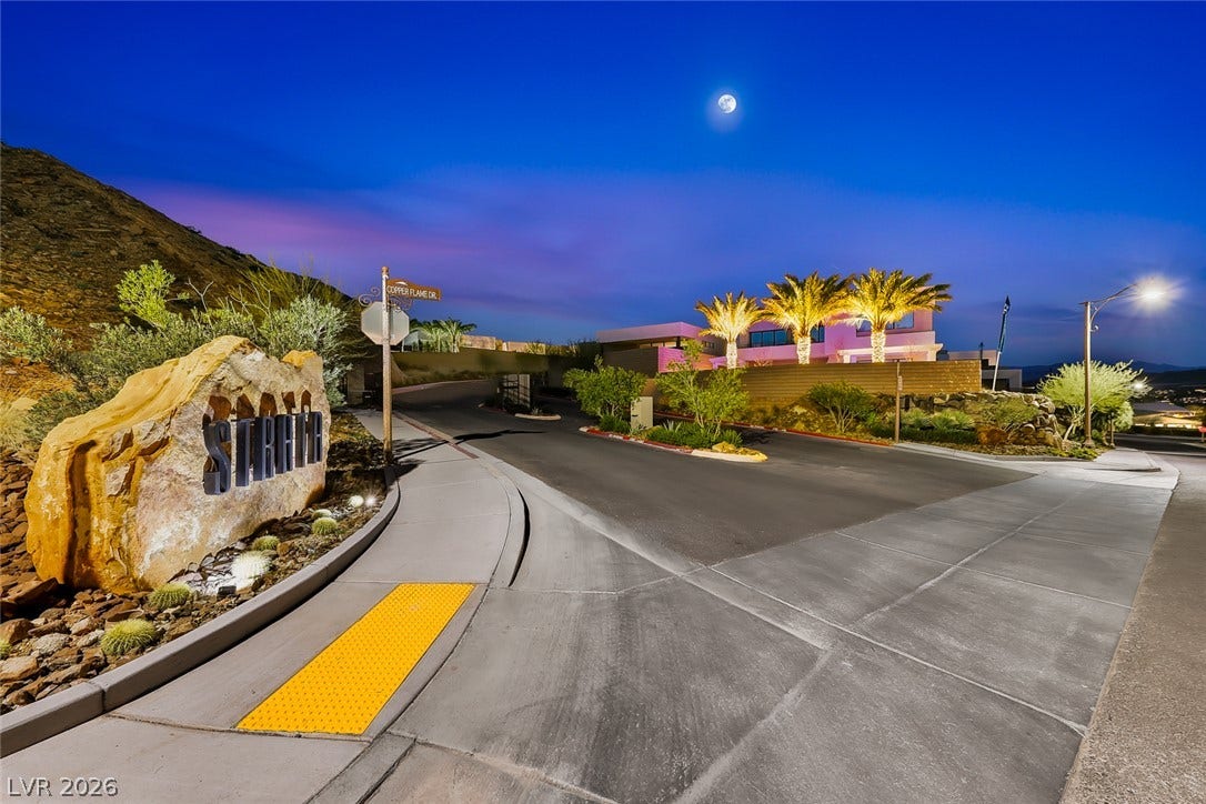 30 Sand Star Lane, Henderson, NV 89011 An inviting gated entrance leads into this hillside luxury community under a twilight sky.