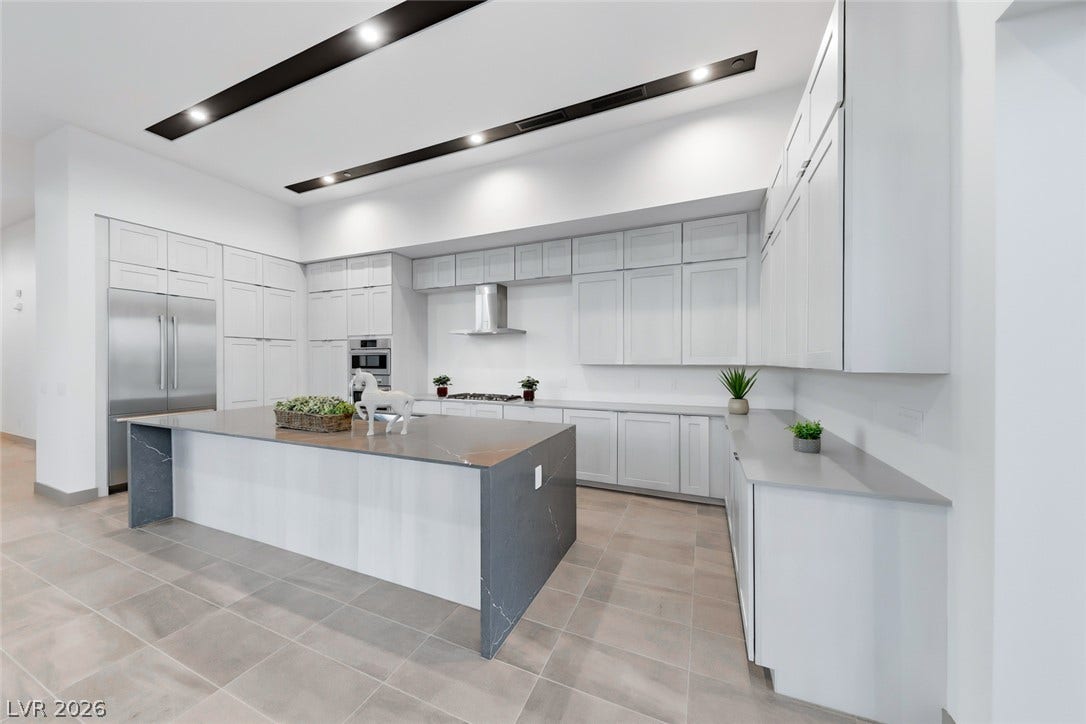 30 Sand Star Lane, Henderson, NV 89011 Gleaming stone countertops and matching custom cabinetry define this modern culinary workspace.