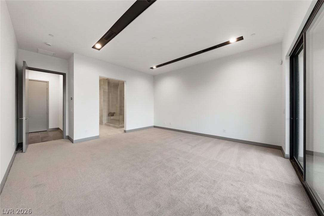 30 Sand Star Lane, Henderson, NV 89011 A minimalist design features recessed linear lighting, plush carpeting, and seamless sliding glass door access.