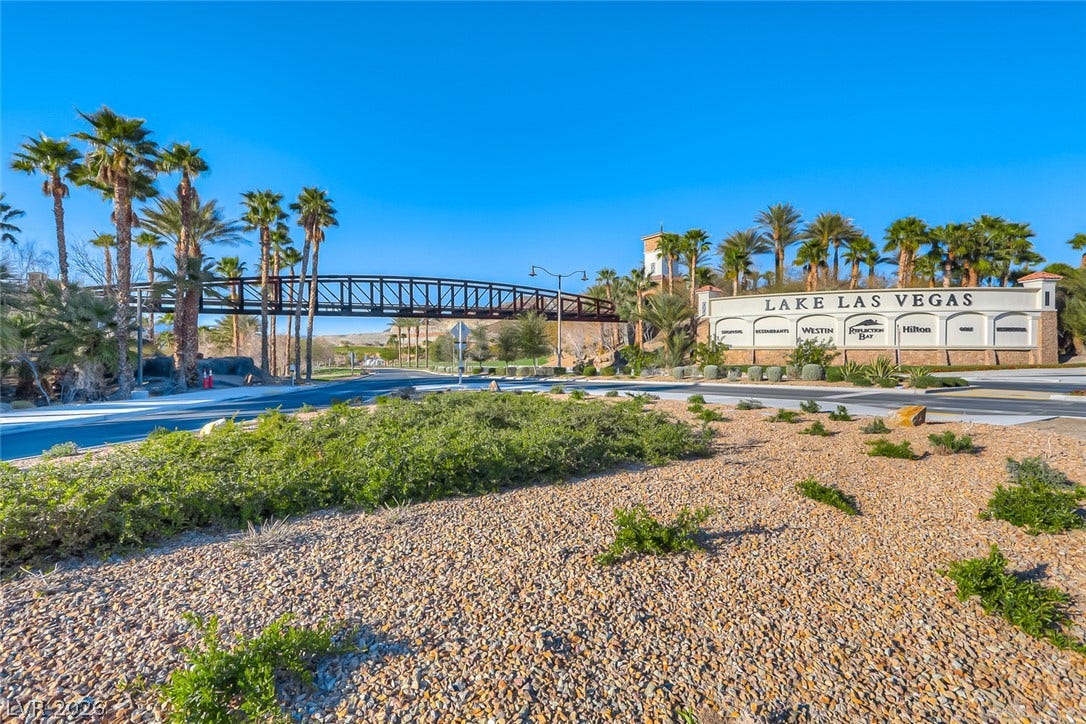 30 Sand Star Lane, Henderson, NV 89011 A grand gated community entrance is framed by desert landscaping and towering palm trees.