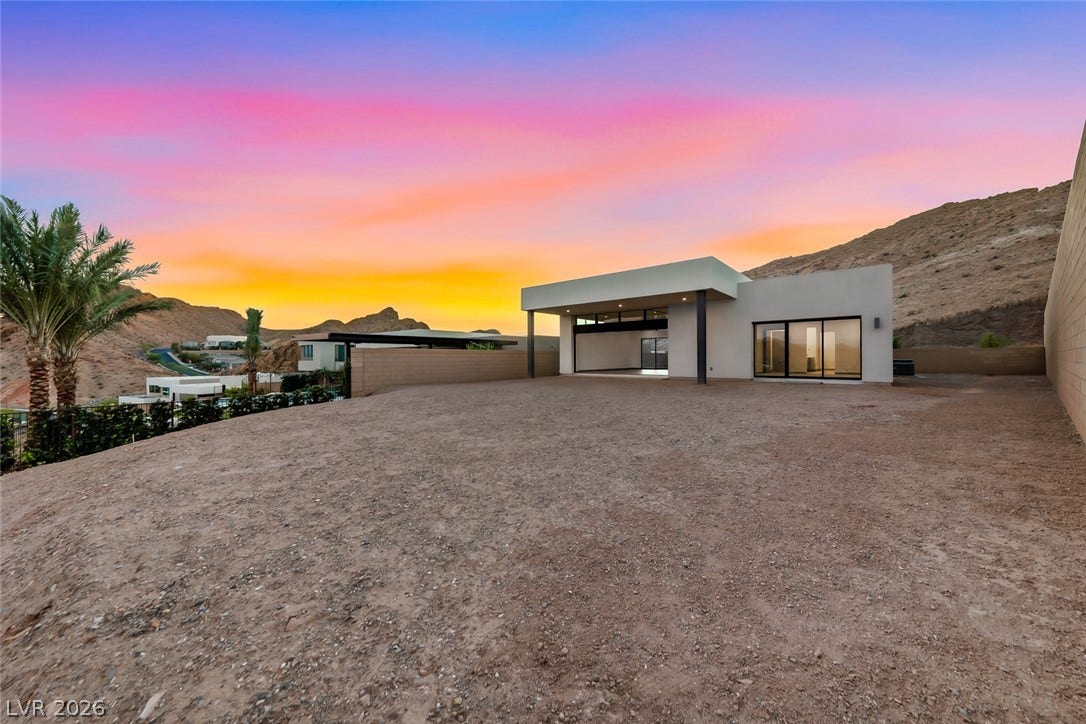 30 Sand Star Lane, Henderson, NV 89011 Dramatic mountain backdrops frame a modern concrete structure under sunset skies.