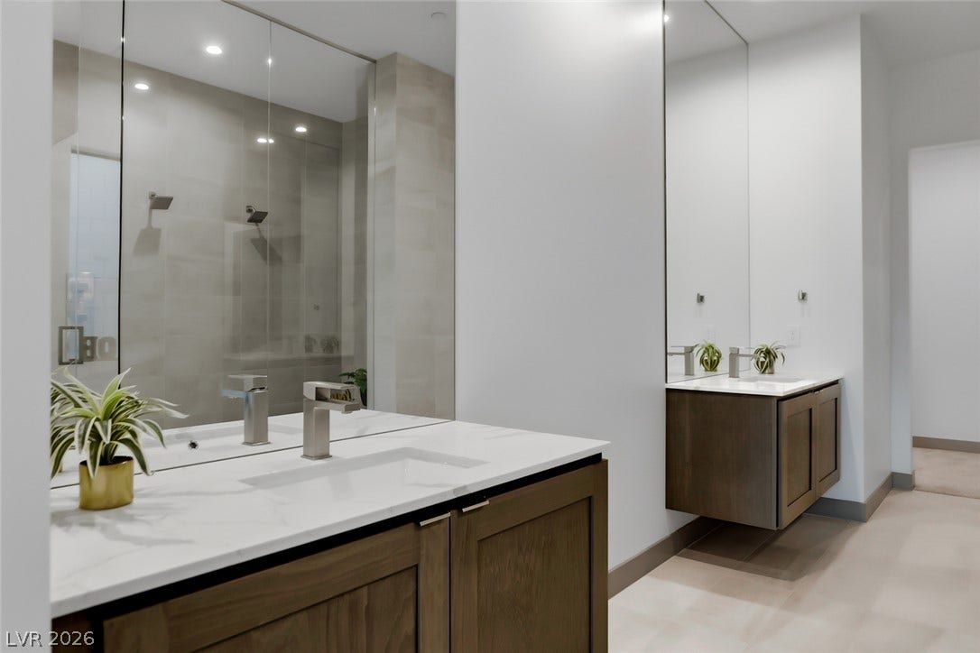 30 Sand Star Lane, Henderson, NV 89011 Floating vanities with stone counters and modern fixtures anchor this minimalist bathroom space.