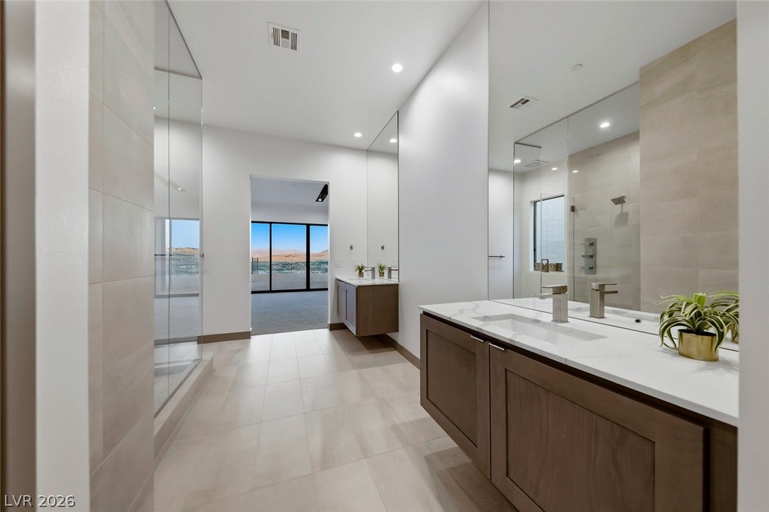 30 Sand Star Lane, Henderson, NV 89011 Sleek floating vanities and large-format tile flooring define this modern primary bathroom.