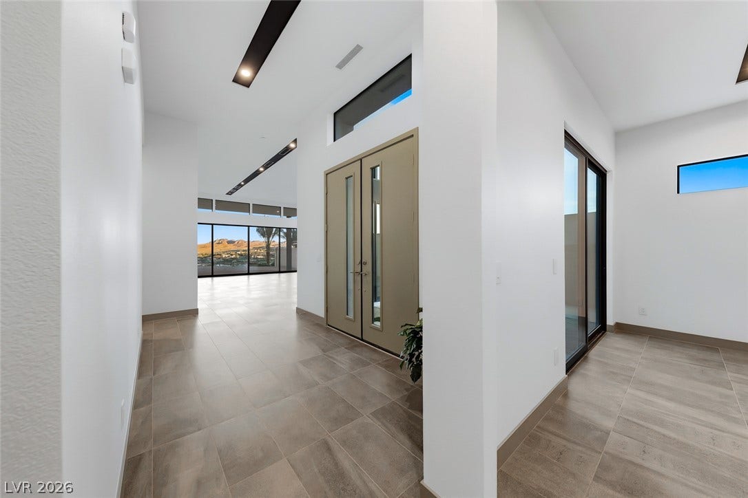 30 Sand Star Lane, Henderson, NV 89011 Gleaming tile floors and soaring ceilings define this modern entryway with desert views beyond.