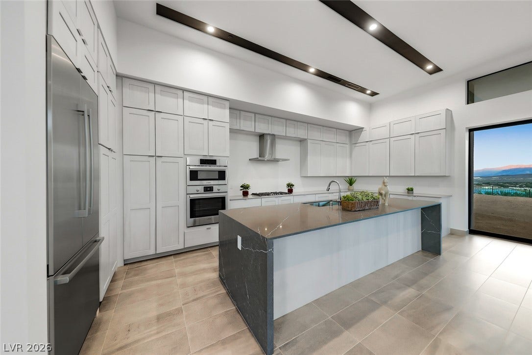 30 Sand Star Lane, Henderson, NV 89011 Dramatic ceiling details and a massive waterfall island anchor this sleek, modern culinary space.