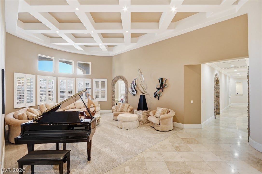 6625 W El Campo Grande Avenue, Las Vegas, NV 89130 An elegant coffered ceiling and arched stone transitions define this grand living space.