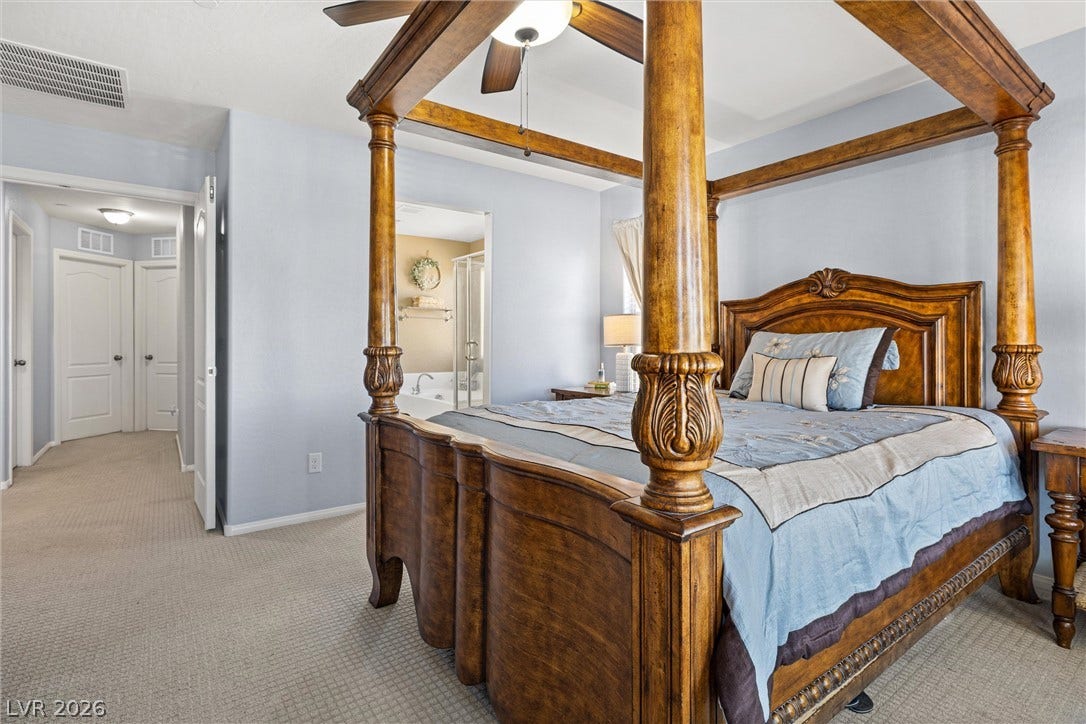 8944 Red Tapestry Court, Las Vegas, NV 89149 A spacious primary bedroom features neutral carpeting and provides direct access to the en suite bathroom.