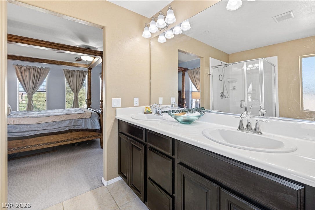 8944 Red Tapestry Court, Las Vegas, NV 89149 A spacious double vanity sits adjacent to the primary bedroom suite.