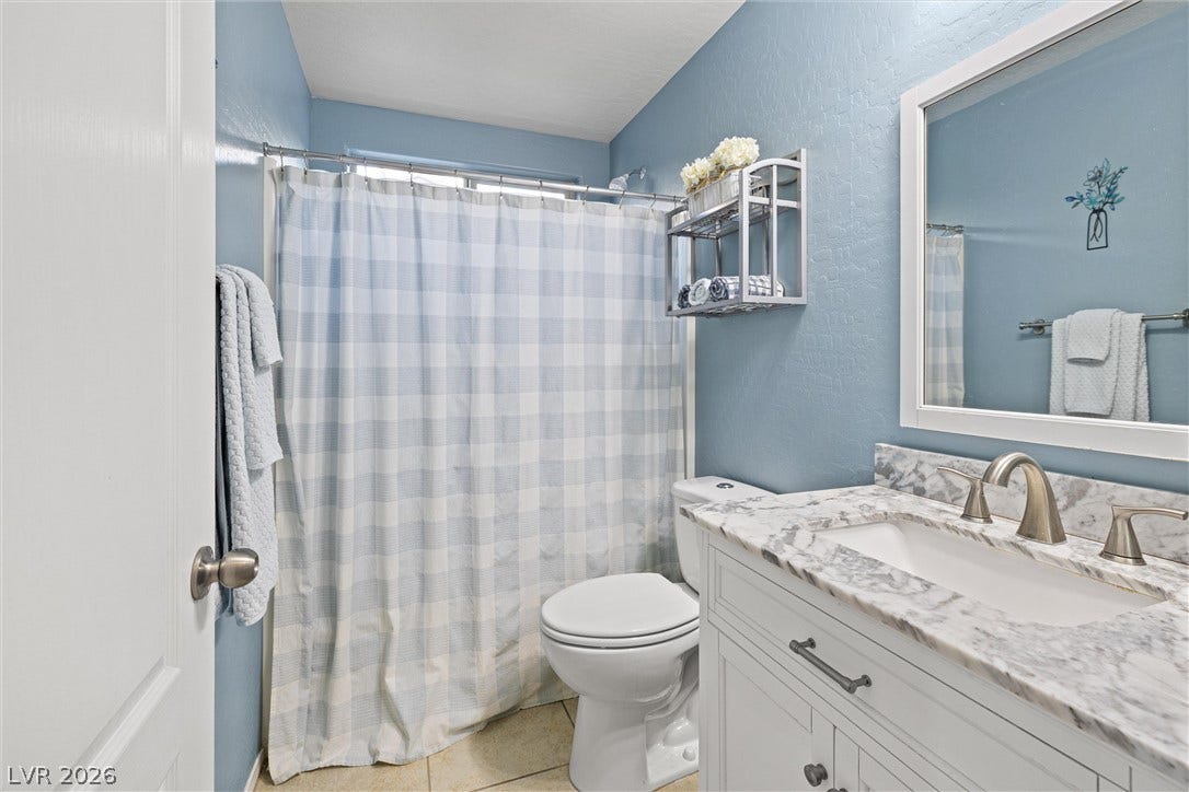 8944 Red Tapestry Court, Las Vegas, NV 89149 Polished countertops and updated fixtures elevate this classic bathroom design.