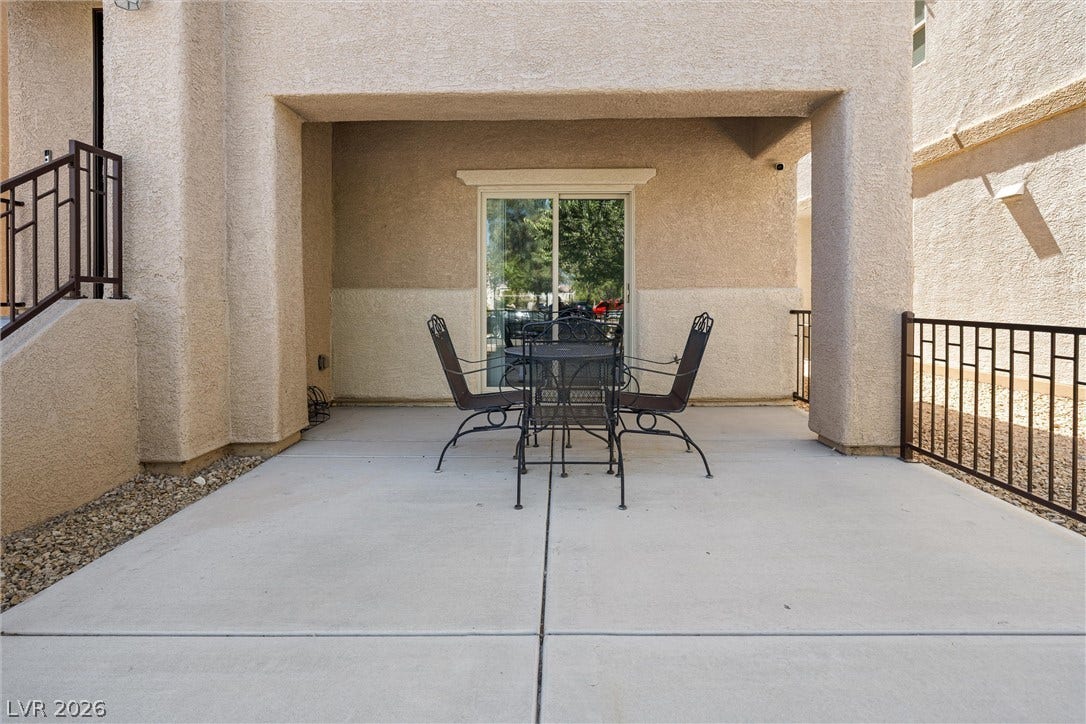 8944 Red Tapestry Court, Las Vegas, NV 89149 Concrete columns frame a sheltered large outdoor dining area finished with stucco walls. Entry into the den.