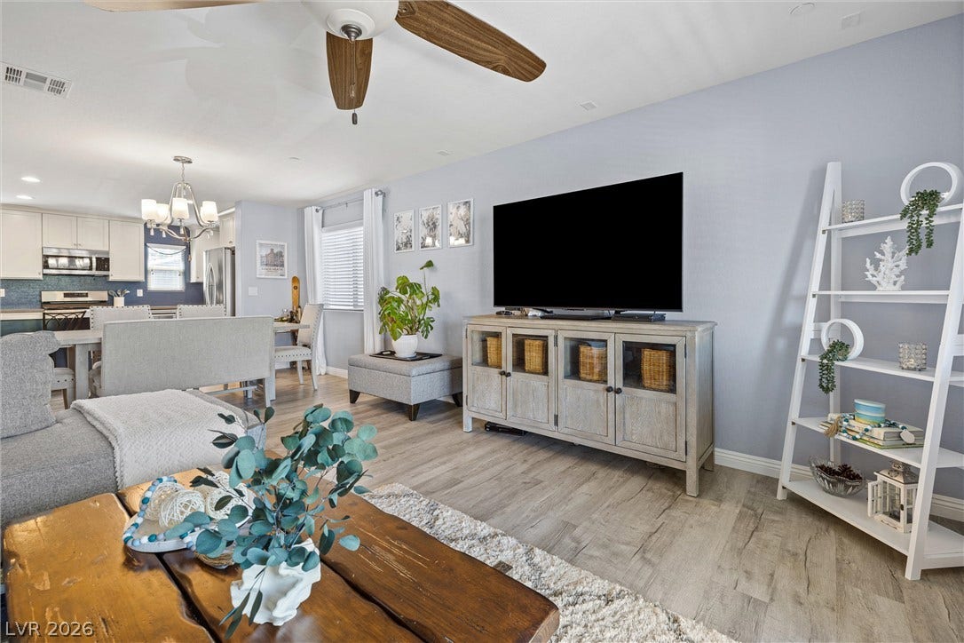 8944 Red Tapestry Court, Las Vegas, NV 89149 Gleaming wood-look luxury vinyl floor anchor this airy living space with high ceilings and recessed lighting.
