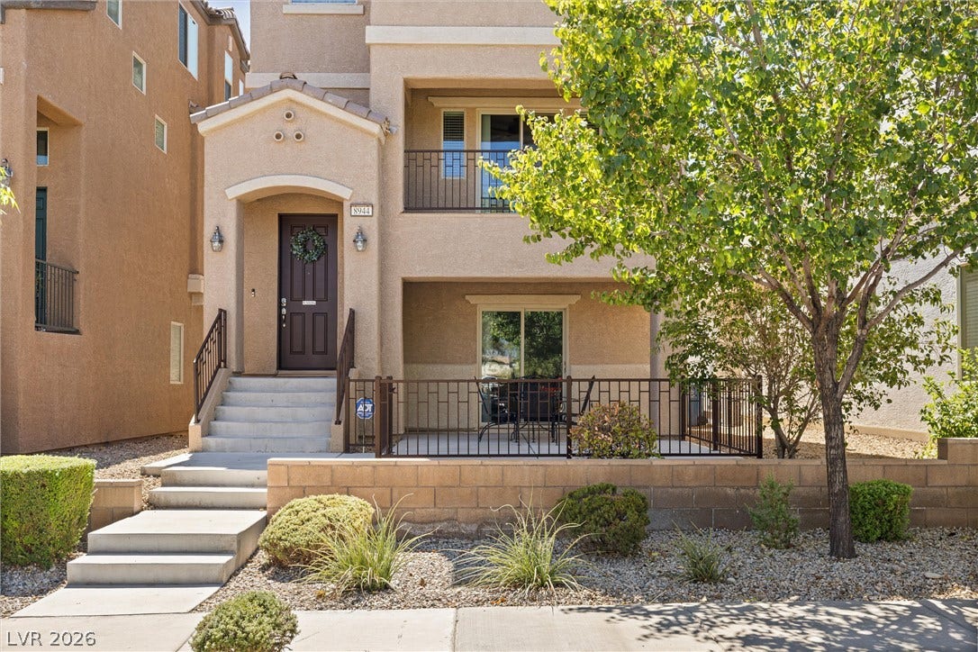 8944 Red Tapestry Court, Las Vegas, NV 89149 Concrete steps lead up to a welcoming stucco entryway flanked by a large patio area.