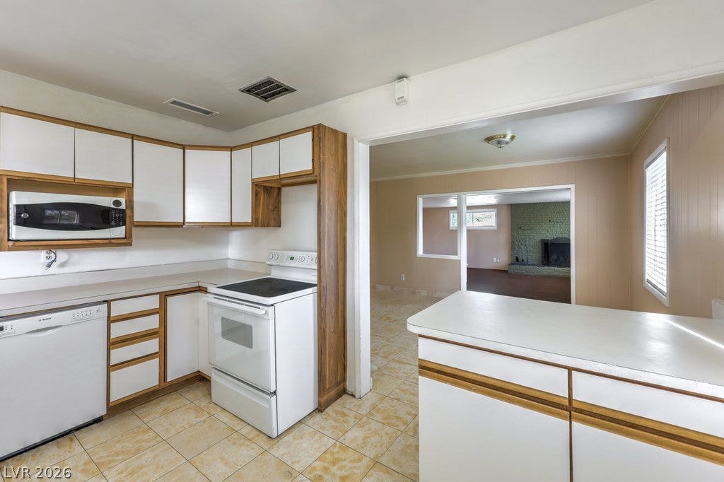 580 Karen Way, Henderson, NV 89015 Tiled flooring and wood-trimmed cabinetry define this kitchen space opening to adjacent living areas.