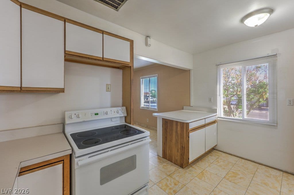 580 Karen Way, Henderson, NV 89015 A functional kitchen features wood-trimmed cabinetry, tile flooring, and abundant natural light.