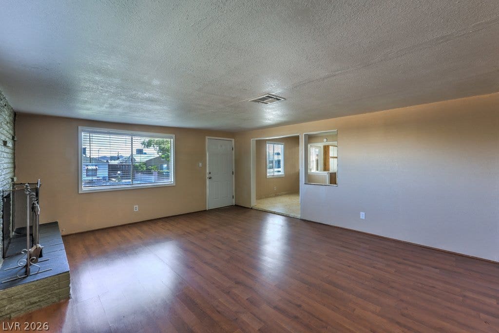 580 Karen Way, Henderson, NV 89015 Warm wood flooring and a classic brick fireplace anchor this versatile living area.