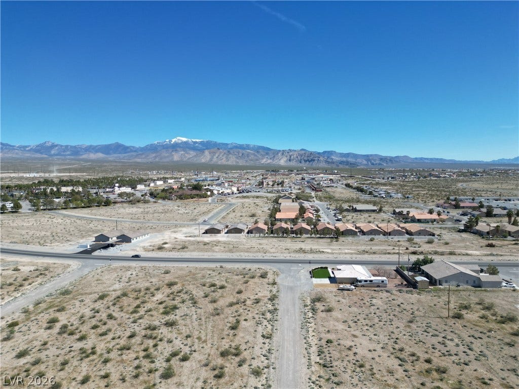 Panoramic mountain ridges frame the distant horizon across a vast desert landscape.