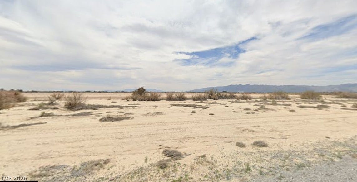 Distant mountains frame the wide horizons of this level desert parcel under open skies.
