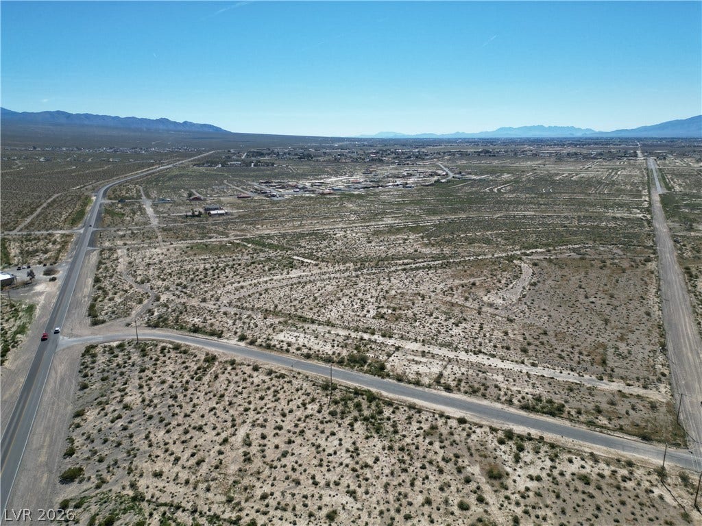 Vast desert acreage offers expansive mountain views and convenient paved road access.