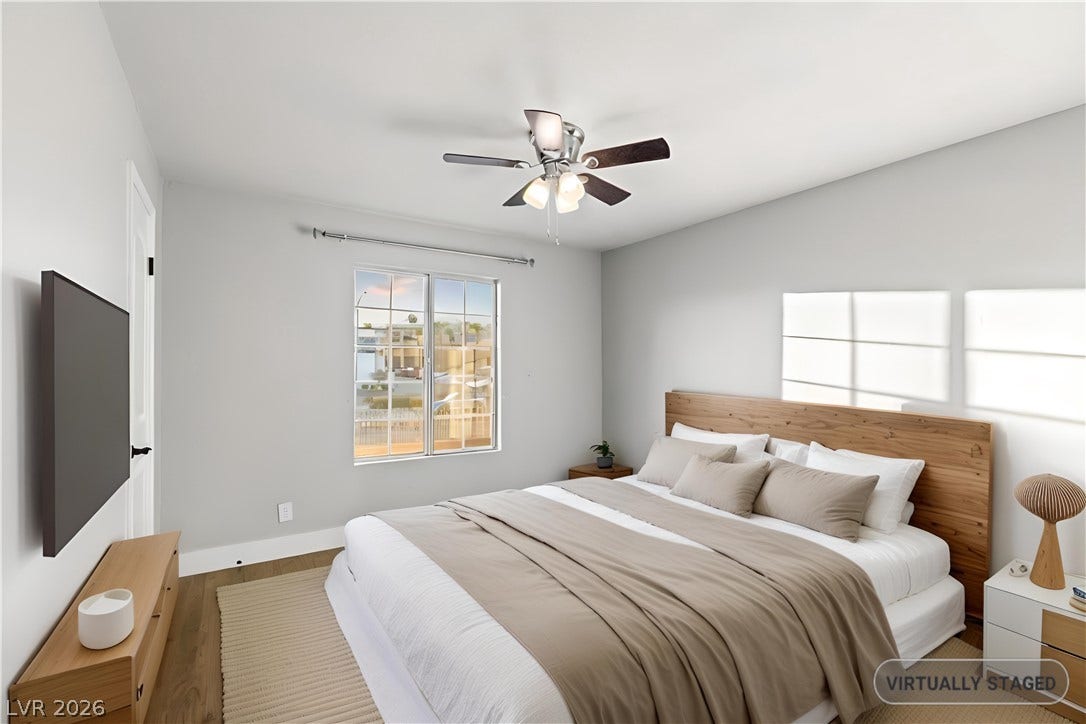 Smooth wood floors and crisp white trim enhance this inviting bedroom space.