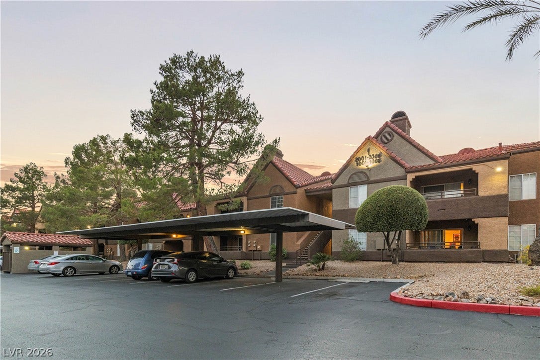 Spanish tile roofs and covered parking spaces define this multi-level residential exterior.