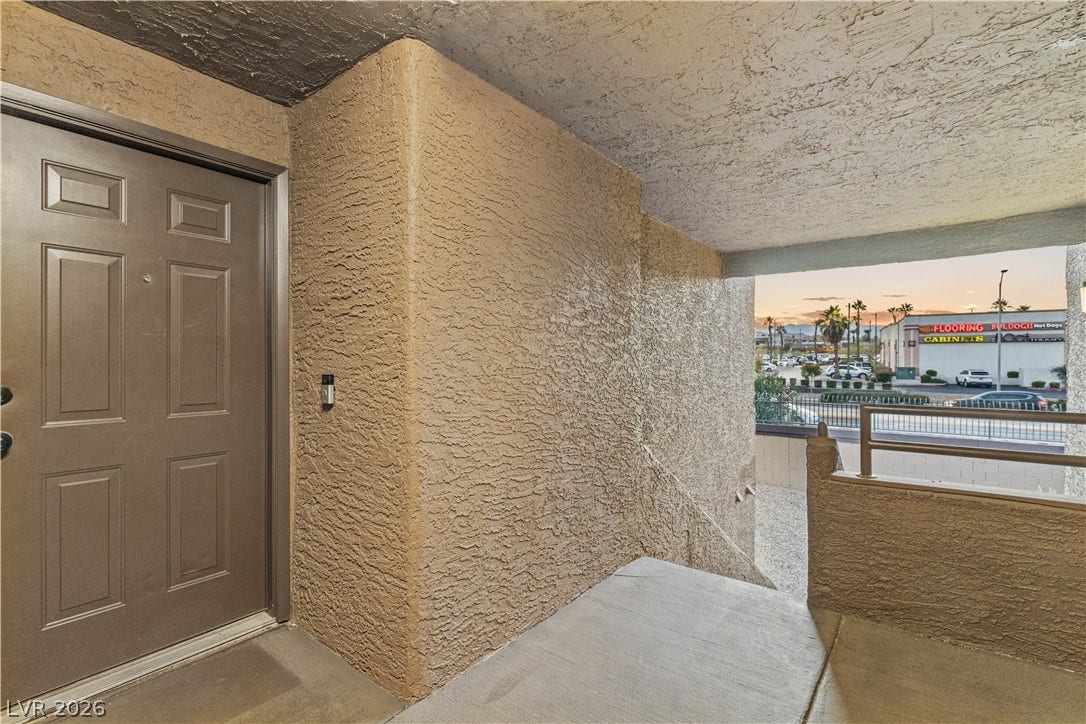 An inviting entrance landing steps down to a concrete staircase framed by stucco walls.