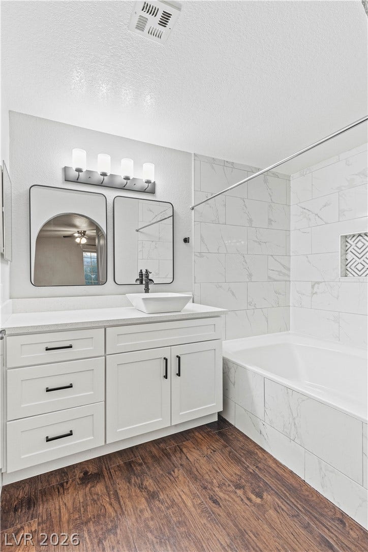 Gleaming stone counters and marble-patterned tile walls elevate this modern bathroom.