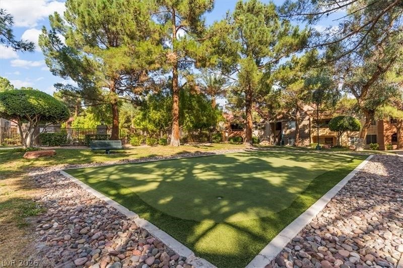 Mature trees shade a manicured putting green within this beautifully landscaped park setting.
