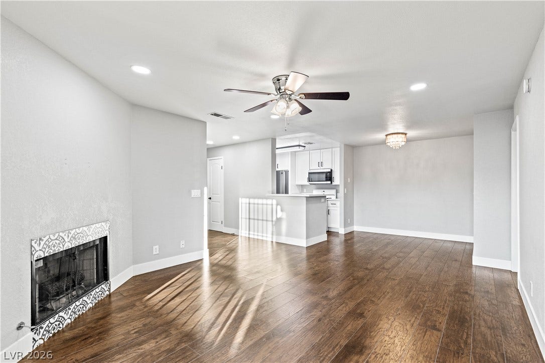 Gleaming hardwood floors flow throughout the open concept living space with a tiled fireplace.