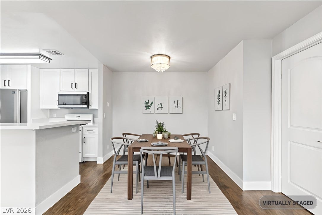 Rich hardwood flooring anchors this versatile space, seamlessly connecting the dining area to the kitchen.