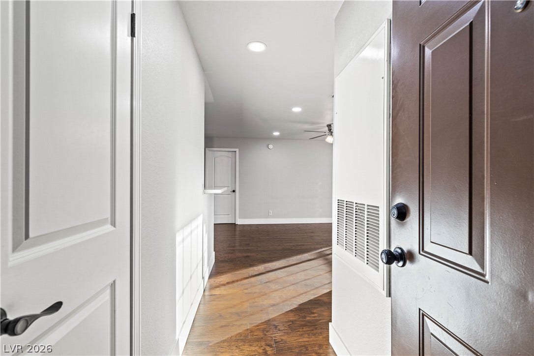 Rich wood flooring runs from the entryway directly into an open main living space.