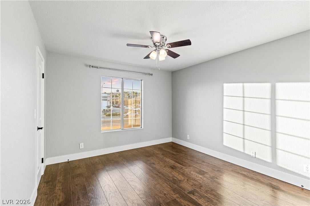 Rich hardwood flooring anchors this versatile space lit by a classic multi-pane window.