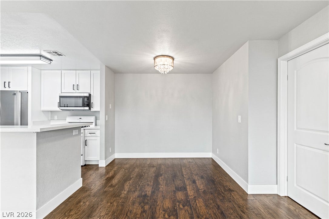 Rich wood floors lay a beautiful foundation in this open dining area adjacent to the kitchen.