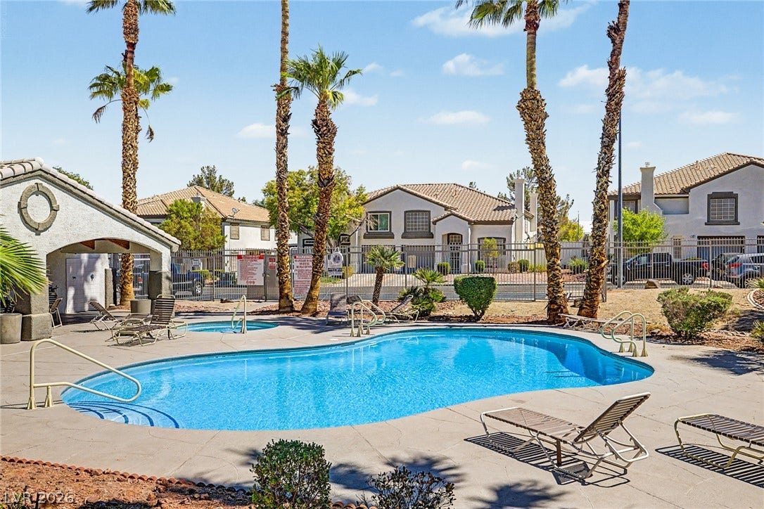 199 Winnsboro Street, Henderson, NV 89074 Mature palm trees frame a sparkling community swimming pool on a clear sunny day.