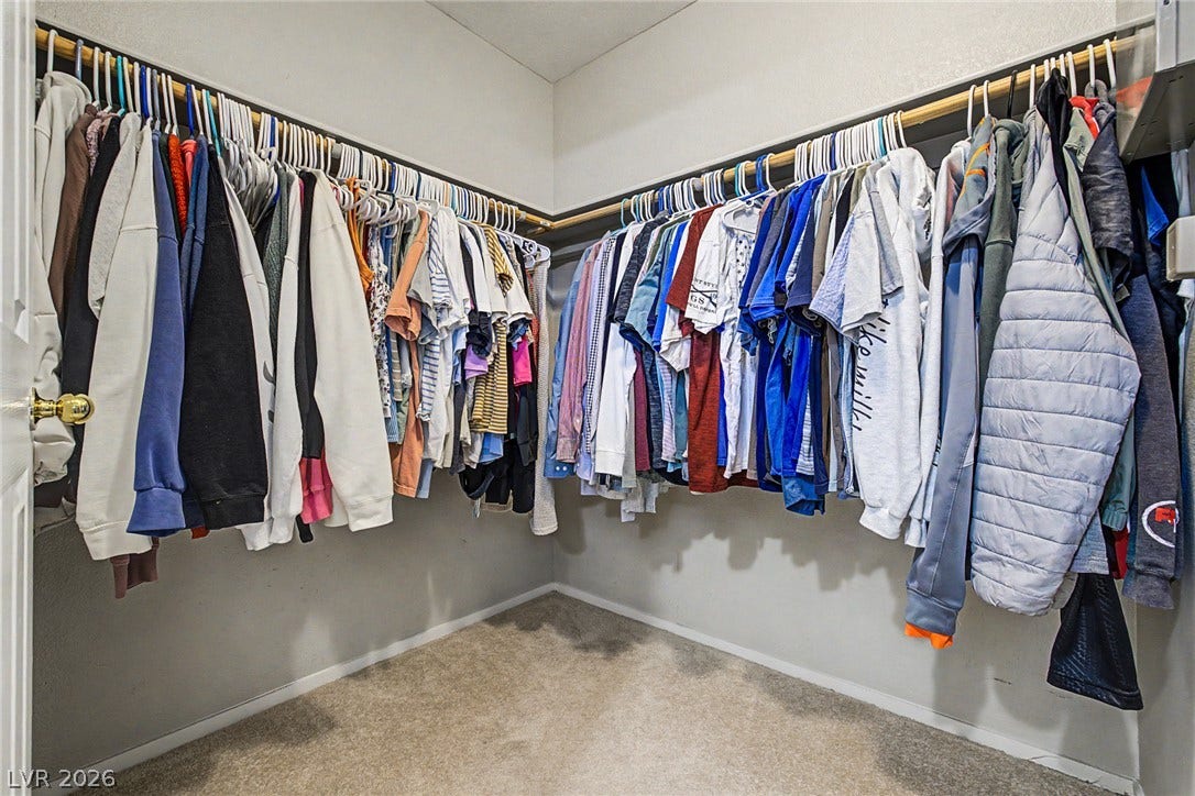 199 Winnsboro Street, Henderson, NV 89074 An organized walk-in closet features wrap-around hanging rods and soft carpeting underfoot.