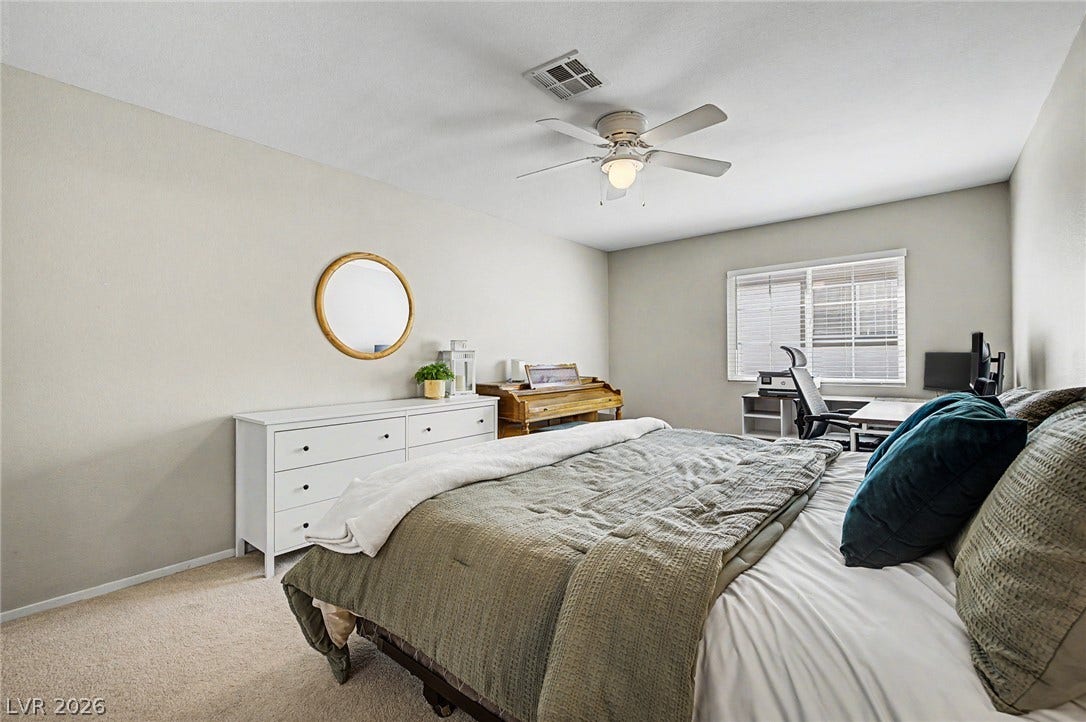 199 Winnsboro Street, Henderson, NV 89074 A spacious bedroom features neutral walls, plush carpeting, and a large window inviting natural light.