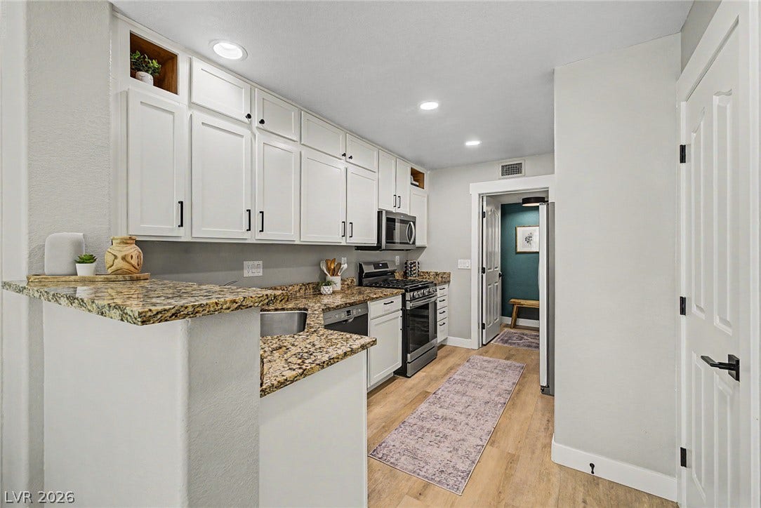 199 Winnsboro Street, Henderson, NV 89074 Polished stone counters and classic cabinetry elevate this bright kitchen space.