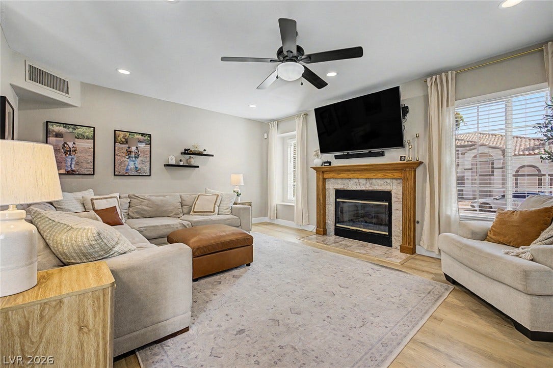 199 Winnsboro Street, Henderson, NV 89074 A classic fireplace with a wooden mantel serves as the focal point in this cozy space.