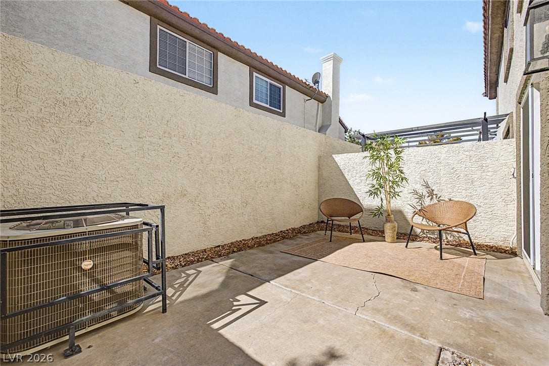 199 Winnsboro Street, Henderson, NV 89074 High stucco walls frame a private concrete courtyard under clear blue skies.