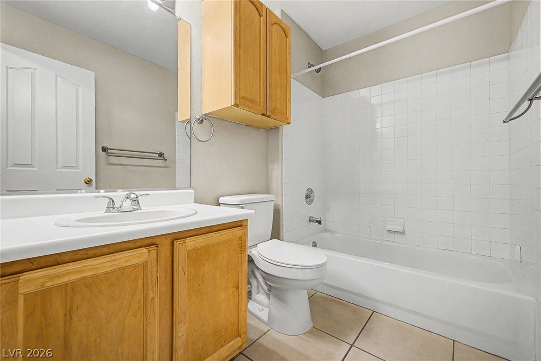 199 Winnsboro Street, Henderson, NV 89074 Tiled flooring pairs with a classic wood vanity and tiled shower surround.