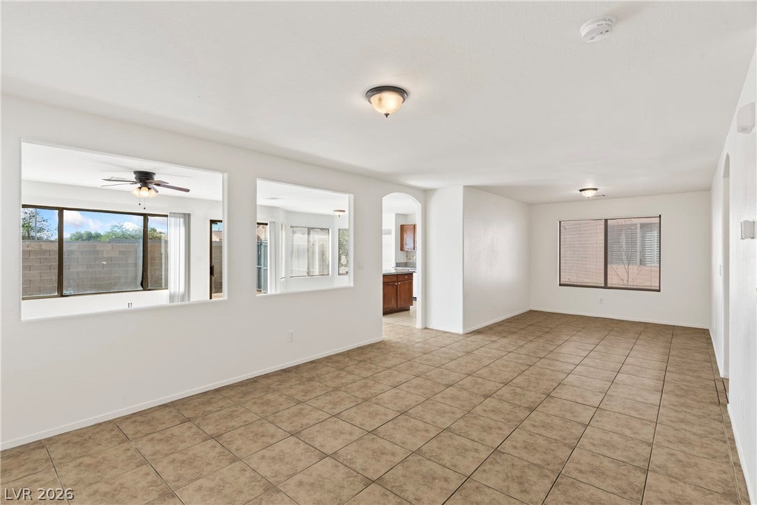 Tiled flooring flows through an open living layout punctuated by interior cutouts and arched doorways.