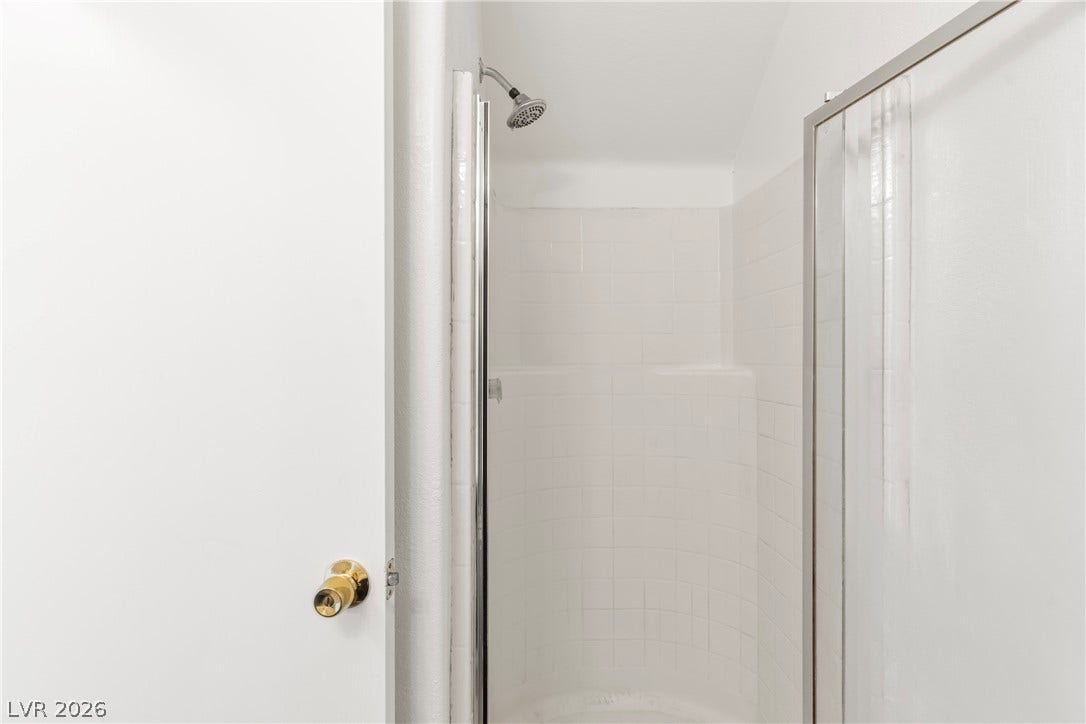 Tiled shower walls and glass door detailing define this secondary bathroom space.