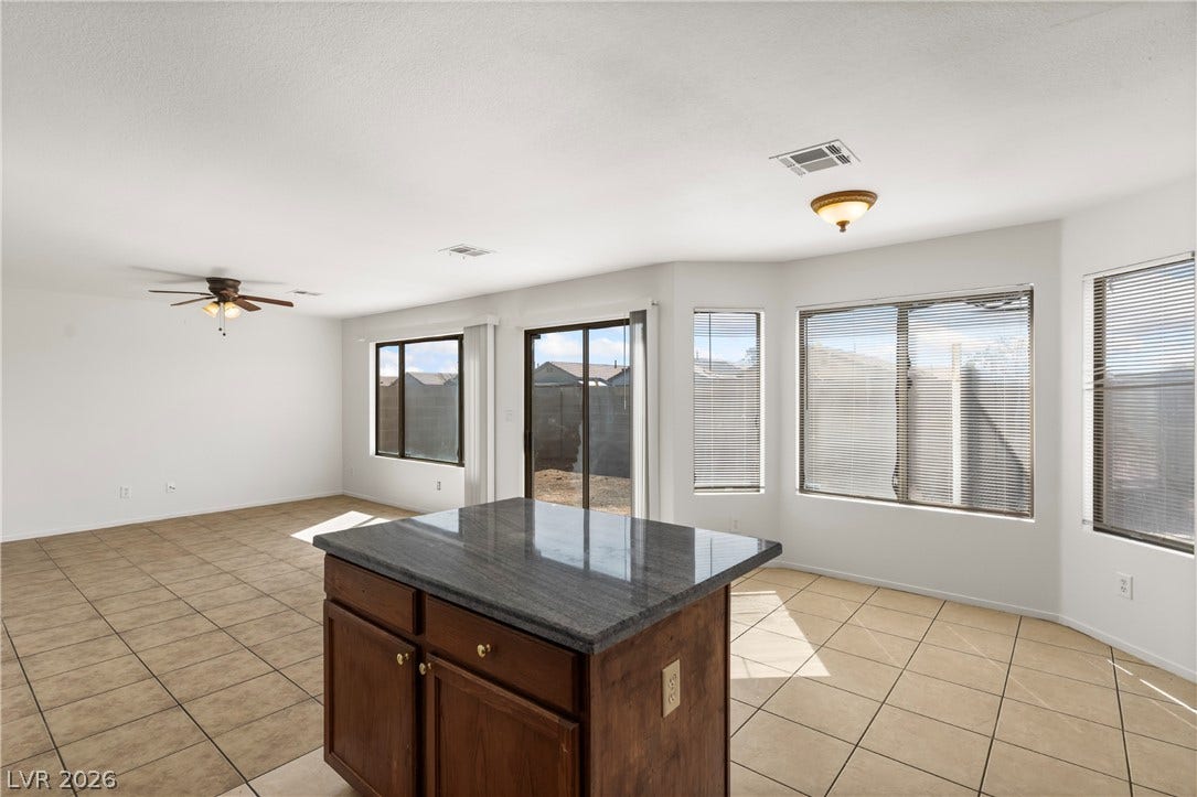 An open living space transitions seamlessly into a bright kitchen area with durable tile flooring.