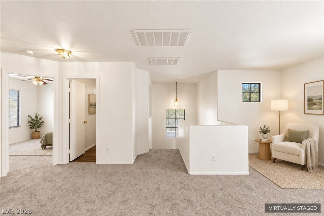 An open upper level landing features soft carpeting and connects to multiple private rooms.
