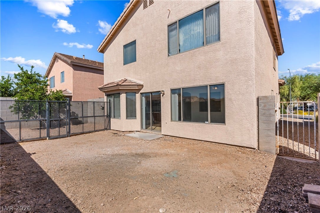 An enclosed backyard space features durable stucco siding and sliding glass door access.