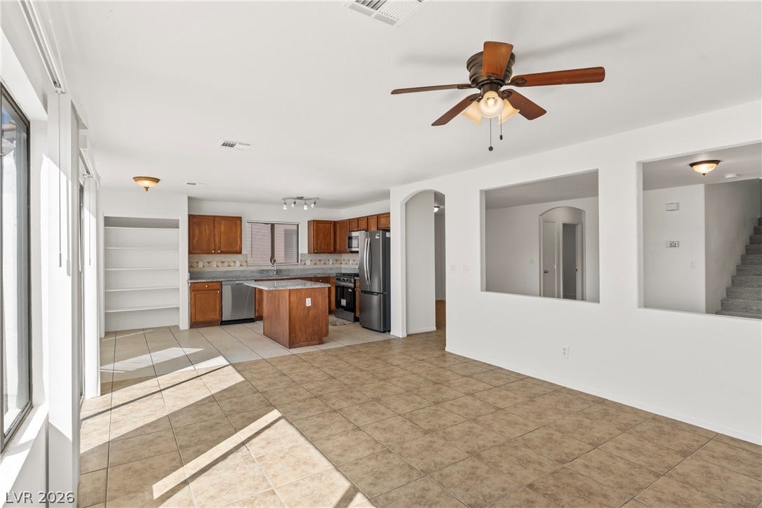 An open floor plan connects the tiled living space directly to the kitchen area.