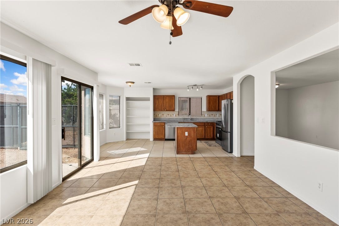 Sliding glass doors fill this tile-floored living and dining area with natural light.